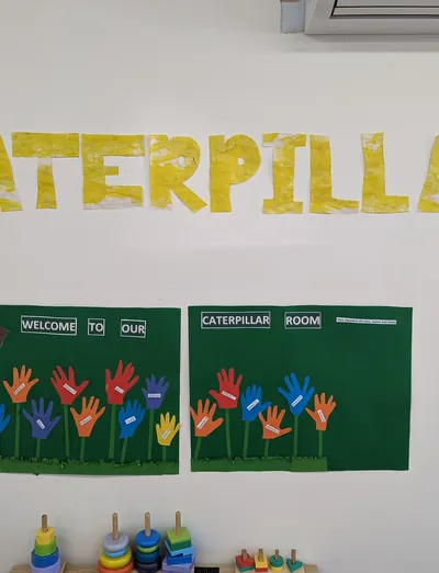Caterpillar Room welcome sign with children's handprints at Lakeside Creative Minds