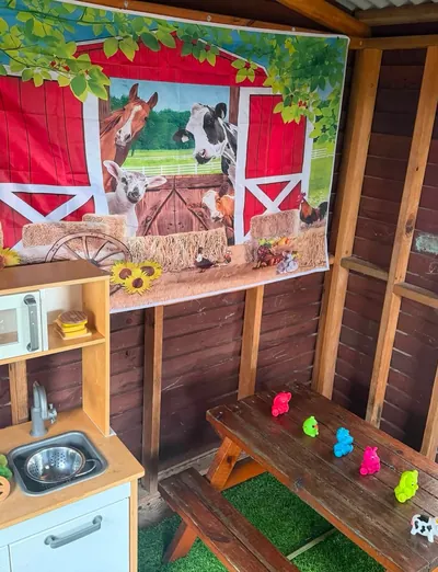 Home corner cubby with a play kitchen and picnic table at Lakeside Creative Minds