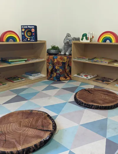 Book shelves and log-style cushions in the reading corner at Lakeside Creative Minds